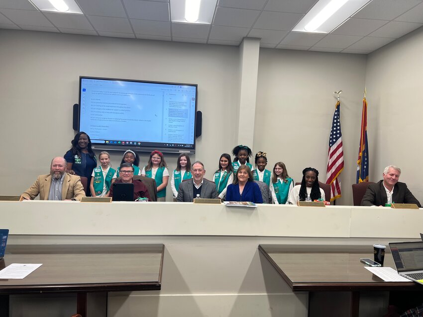 Pictured behind the board, from left, are Troop Leader Sheree Thompson, Gracie Shaffer, Mary-Elle Berry, Molly Grace Reiber, Briley Daniel, Lilleigh Newell, CaLeigha Thompson, Aubree Walker and Brantley Hamil.