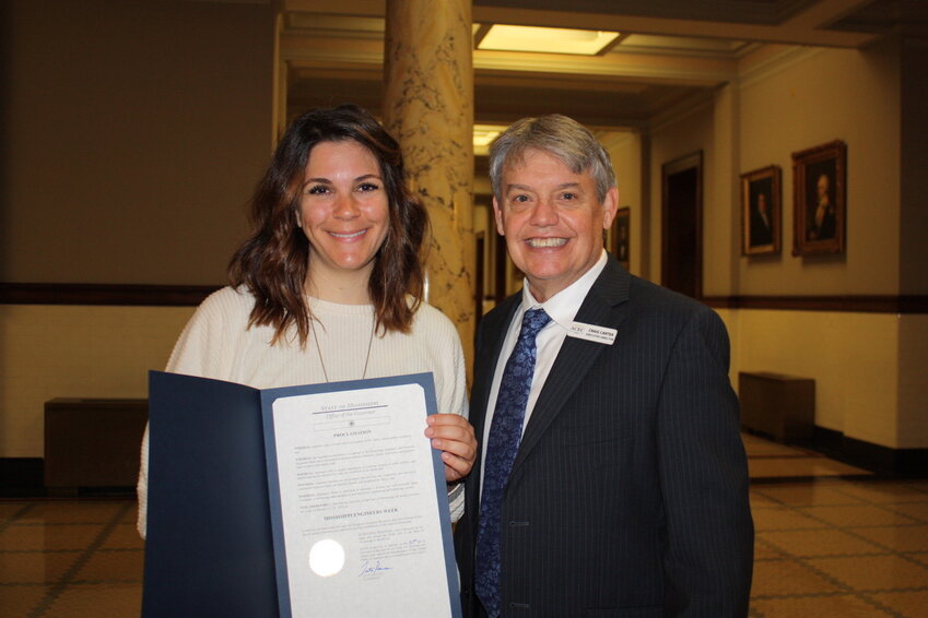 Amber Reeb of Burns Cooley Dennis with Madison County resident Craig Carter, Executive Director of ACEC/MS. They are holding the proclamation by Governor Tate Reeves announcing Mississippi Engineers Week.