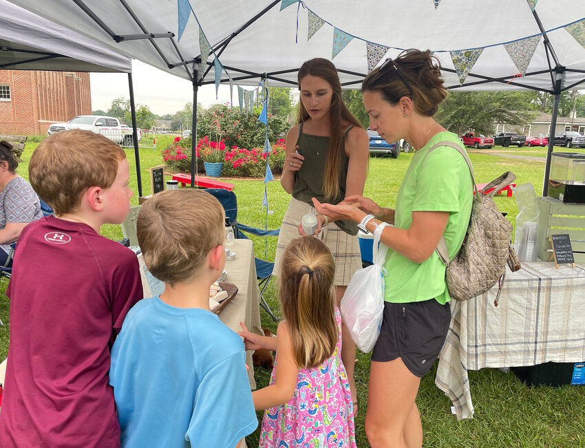 A family checks out some homemade soaps and creams at one of the vendors at the Madison Famer’s Market.