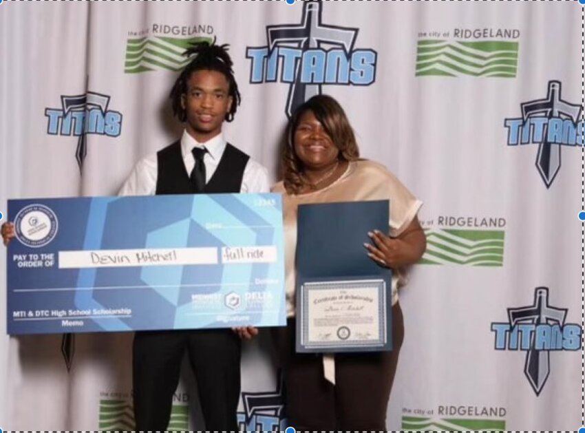 Devin Mitchell is presented his scholarship by a representative of Delta Technical College.