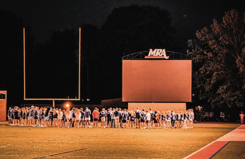 MRA students gather on the field on Monday night following a prayer service at the school remembering senior Robert Noah who was killed in a car wreck over Labor Day weekend. Students lit candles and sang together.