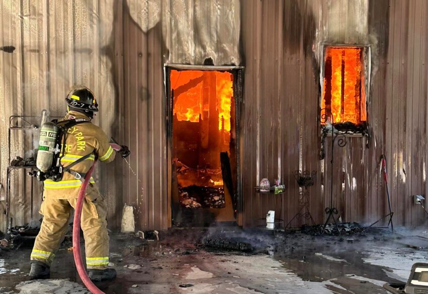 Firefighters with the Flora Fire Department battle a blaze off Virlilia Road Tuesday.