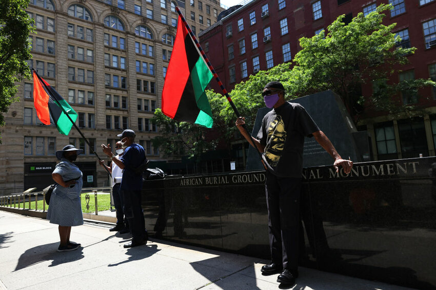 NEW YORK, NEW YORK - JULY 23: People wait for the start of a rally for reparations at the African Burial Ground National Monument on July 23, 2021 in New York City. People gathered for a rally calling on reparations for descendants of formerly enslaved people organized by December 12th Movement, at the African Burial Ground National Monument. The organization is calling on support of the recently passed slavery reparations bill by the New York State Assembly. The bill will form an 11 person committee comprised of lawmakers and people in the community that would decide how reparations will be paid out. The bill will now be voted on by the Senate with the organization calling on Gov. Andrew Cuomo to sign the bill before the end of the year.   (Photo by Michael M. Santiago/Getty Images)