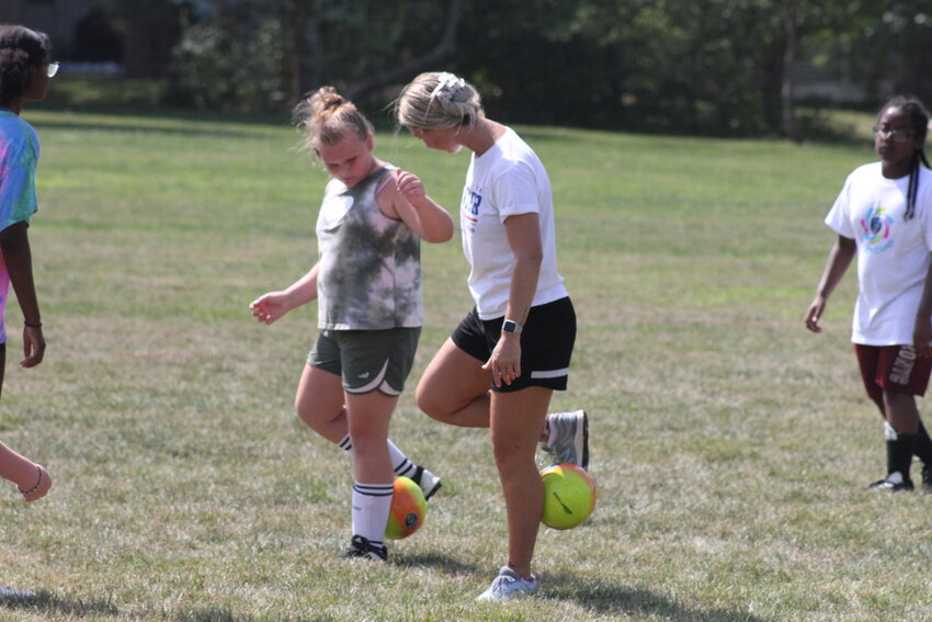 Gabrielle Oakes from Challenger Sports demonstrates how to handle the ball on Friday during a youth soccer camp at Fairgrounds Park in Mexico. Oakes is from England, originating from an overseas country like the other instructors with the Kansas-based Challenger. The camp has come to Mexico for at least 20 years to give area kids another perspective when it comes to learning soccer.