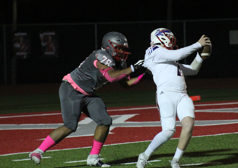 Mexico junior Daunte Cline grabs hold of Moberly quarterback Jackson Engel this season.