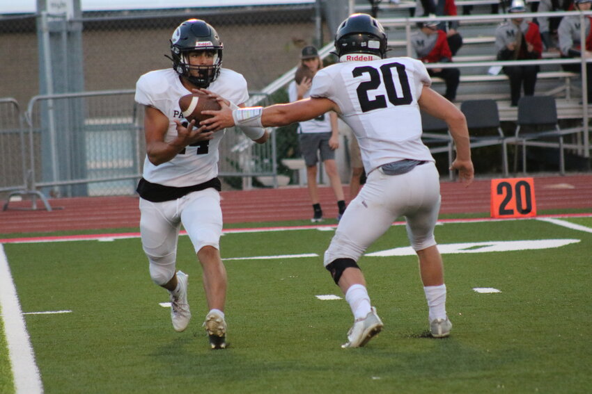 Centralia sophomore Ethan Ross takes a handoff from junior Rex Bryson during the Panthers' Week 1 game at Mexico.