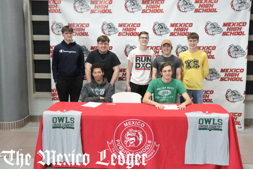 Mexico seniors Landon Higgins (left) and Tyler Grimes (right) gather with teammates on Thursday at the Mexico Sports Complex while signing to run cross country and track and field at William Woods University.