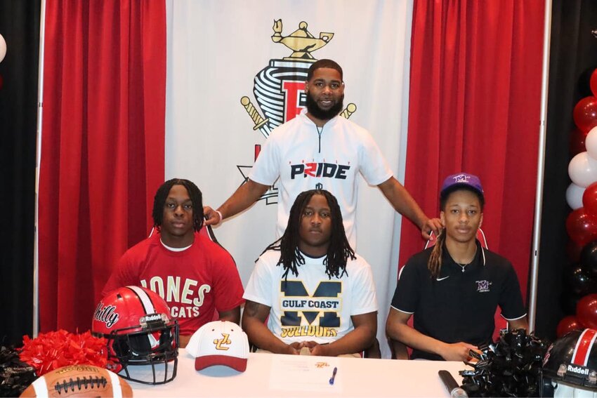 Pictured, seated from left are, Bernard Parker, Christopher Rush, and Dylan Graham. Standing in back is football Head Coach Georgio Grace.