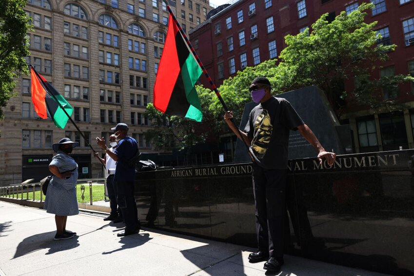 People wait for the start of a rally for reparations at the African Burial Ground National Monument on July 23, 2021 in New York City. People gathered for a rally calling on reparations for descendants of formerly enslaved people organized by December 12th Movement, at the African Burial Ground National Monument. The organization is calling on support of the recently passed slavery reparations bill by the New York State Assembly. The bill will form an 11 person committee comprised of lawmakers and people in the community that would decide how reparations will be paid out. The bill will now be voted on by the Senate with the organization calling on Gov. Andrew Cuomo to sign the bill before the end of the year.