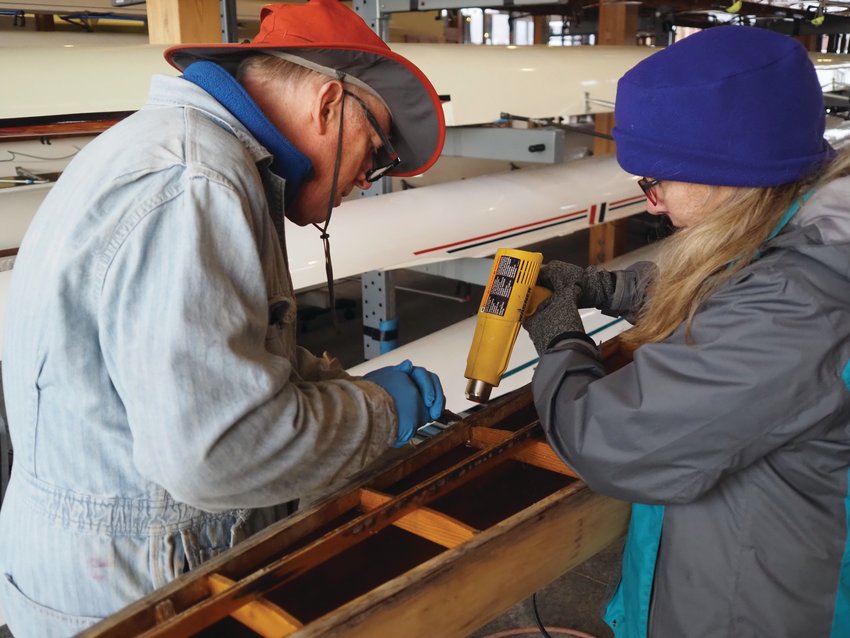 Dave Winters and Peggy Myre work in tandem on restorations to the newest historic Pocock vessel in the rowing club’s collection.