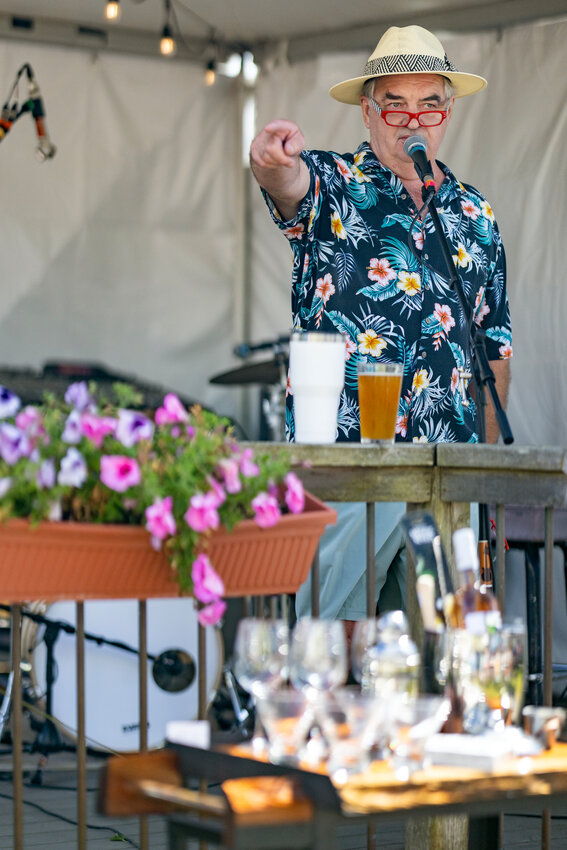 Kiwi Ferris signals to a member of the audience during the live auction Saturday at Port Townsend Brewing. Debi Saxton peers into baskets filled with donations from local businesses in East Jefferson County. 
