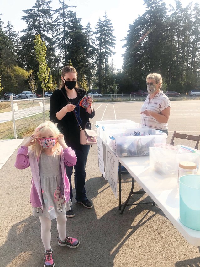 Megan Eisenman and her daughter Lily receive masks made for the students and families of Salish Coast Elementary School by volunteers with Face Mask Challenge Port Townsend.