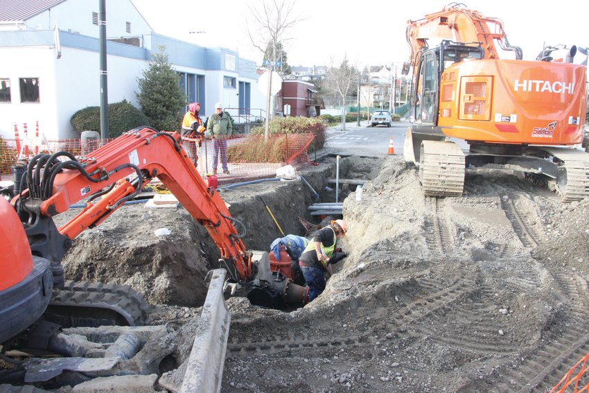 Workers repair a broken section of a water main along Port Townsend's Water Street.