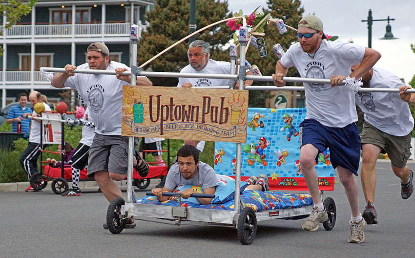 A team pushes their entry down Washington Street during the Port Townsend Rhododendron Festival's bed race.