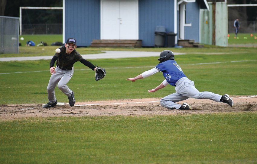 Nathan Nisbet of the Rivals attempts a steal from second base, sliding into third base while Rangers third-baseman Aiden Cate tries to tag him out.