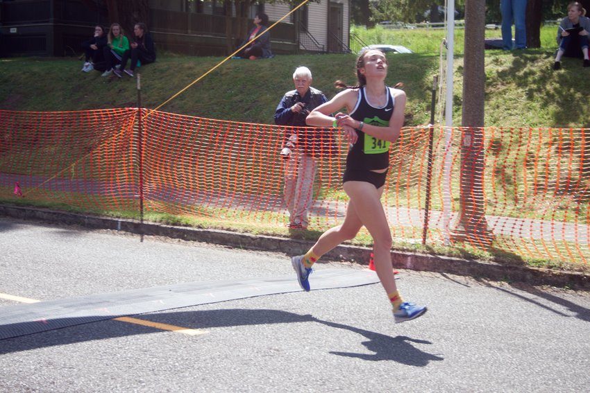 A runner in a pre-pandemic Rhody Run crosses the finish line. The popular fundraising race returns May 22 after a two-year layoff.