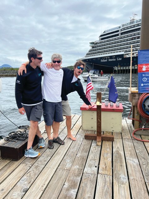 Alyosha Strum-Palerm, Jonathan McKee, and Matt Pistay of Team Pure &amp; Wild celebrate their Race to Alaska victory by ringing the R2AK bell, officially marking their position as the 2022 winners.
