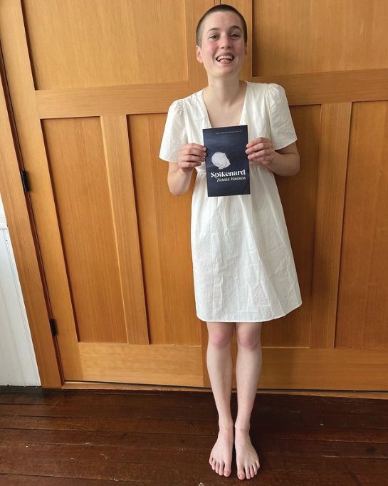 Local high school graduate and Seattle Youth Poet Laureate 2021/2022 Zinnia Hansen holding her new collection of poetry.