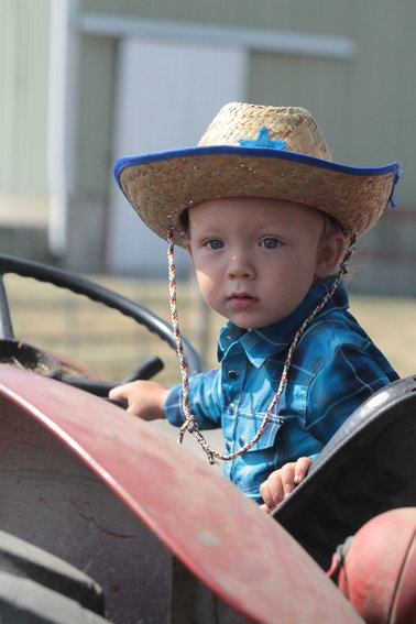 Ronan Andrews takes a seat on a tractor at the Jefferson County Fair so his parents, Lissy and Christian Andrews, can get a photo.  With the fair out of commission due to COVID the past few years, this year&rsquo;s fair was the first for Ronan, who is 19 months old.