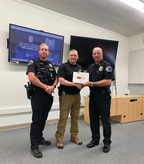 Port Townsend Police Officer Patrick Fudally (center) is handed the Life-Saving Award by Chief Thomas Olson (right) and Detective Jon Stuart (left) for his swift actions that saved a man&rsquo;s life in late July.