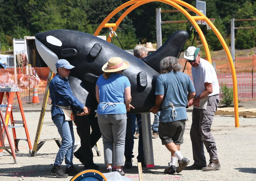 Volunteers with JUMP! help to move a large, climbable orca structure, which will add to the playground&rsquo;s sea theme.