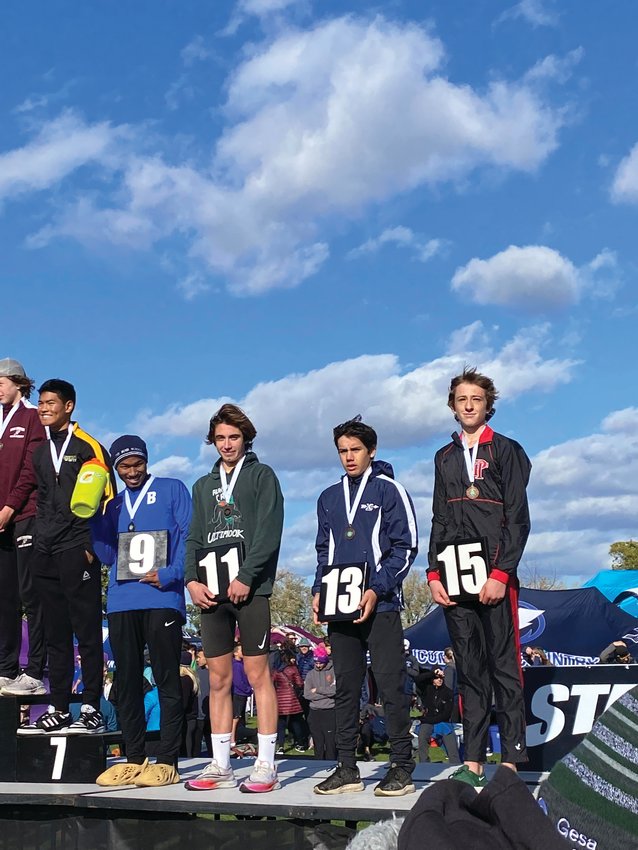 EJ runners Sebastian Manza and Soare Johnston pose on the podium after 11th and 15th in the State Championship race, respectively.