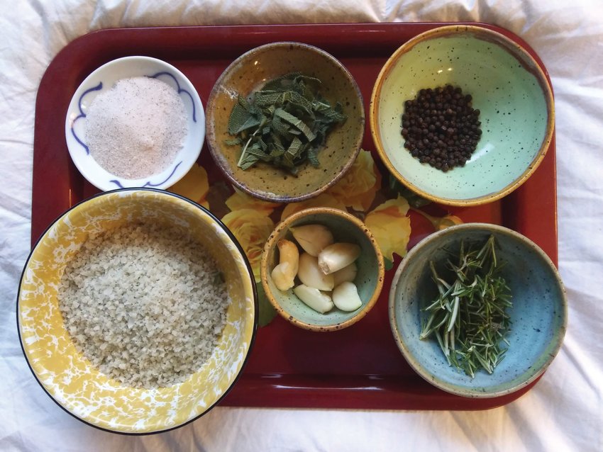 Garlic, peppercorns, sage, rosemary leaves, and other ingredients are ready to be combined for a batch of Sale Alle Erbe delle Port Townsend.