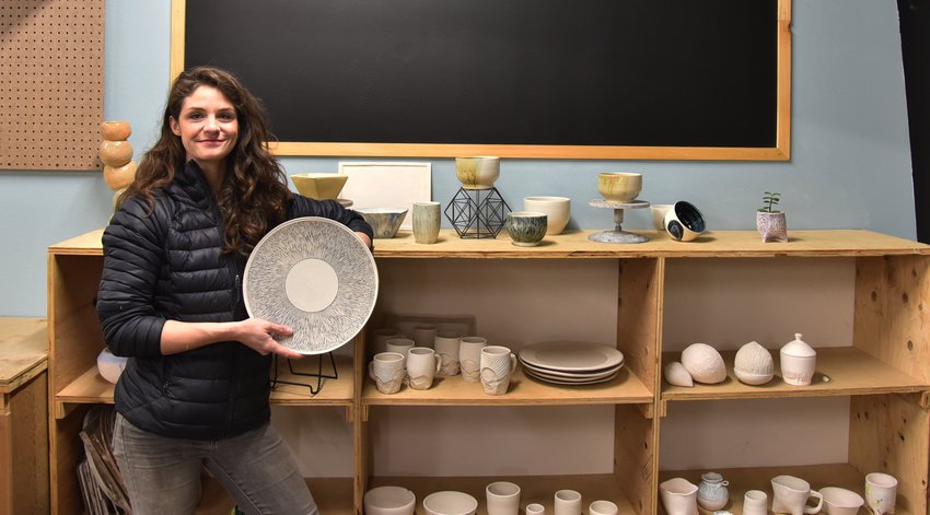Tori Power poses with pottery in her new studio she owns with her partner Mike McGregor.