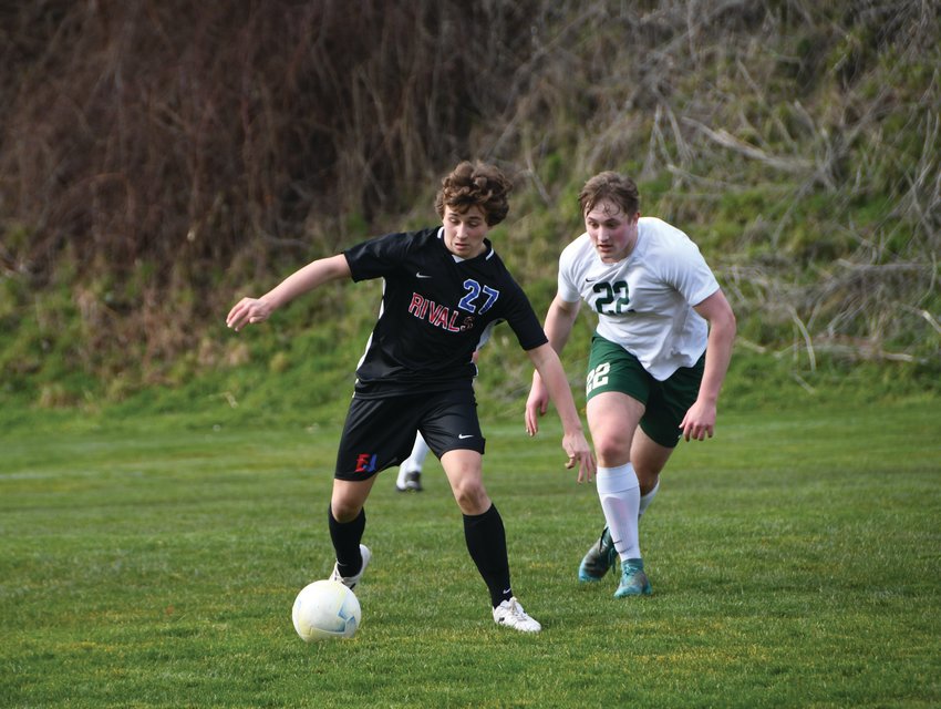 EJ midfielder and freshman Grady White carries the ball forward on his right foot, dribbling upfield in search of a pass.