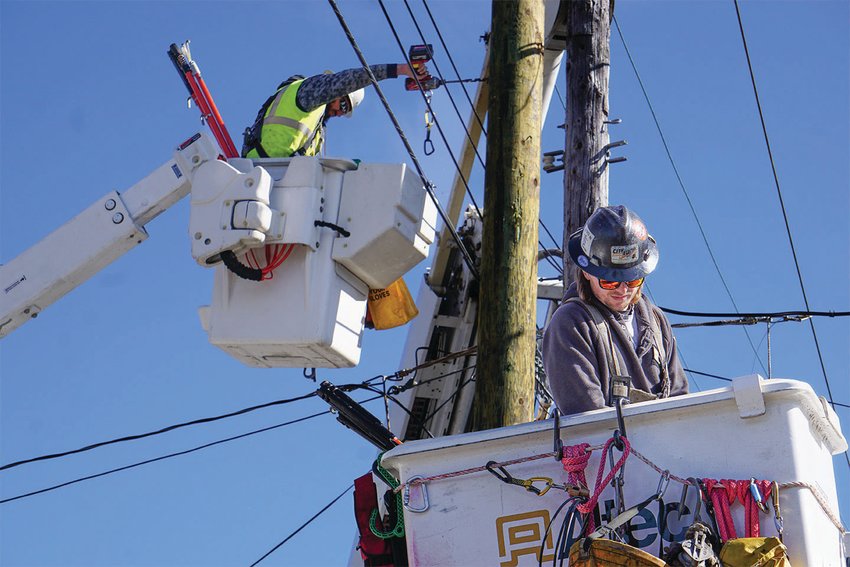 Jefferson County Public Utility District line crew members Jonathan Dehnert (left) and Keith Halsey (right) complete a distribution pole changeout on Port Townsend&rsquo;s Lawrence Street, replacing a rotting pole by utilizing the &ldquo;cut and kick&rdquo; technique.