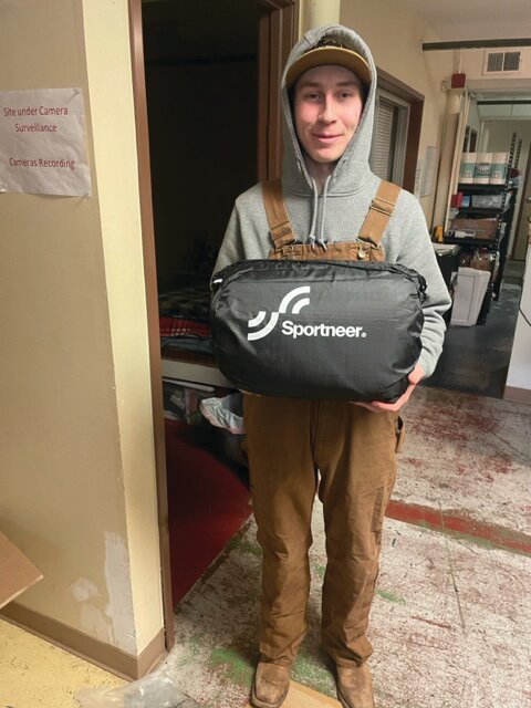 Connor Scanlon stands at the American Legion with a sleeping bag he obtained through a fundraising effort and donated to the local shelter.