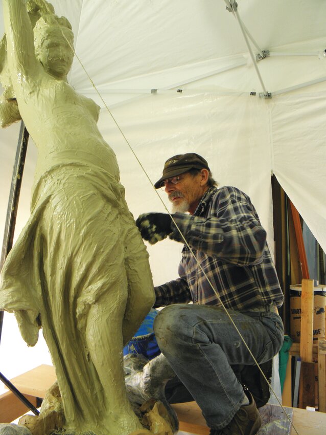 Mark Stevenson applies rubber mold to the figure; the first step in the casting process.