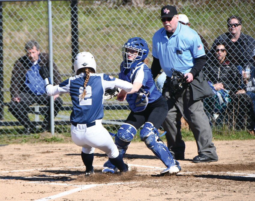 Rivals catcher Rylee Spainhower-Oas attempts to tag an opponent out at home plate during an EJ softball matchup in April.