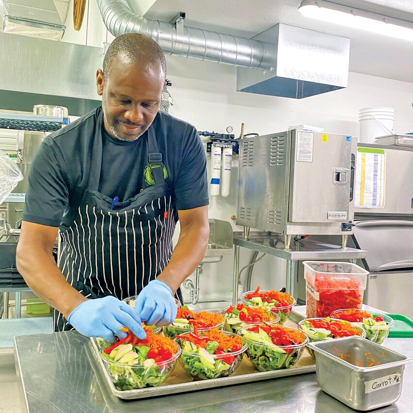 Julian Harris prepares salads at the temporary Jefferson Healthcare kitchen at the Jefferson County Fairgrounds to be transported to patients and staff at the hospital.