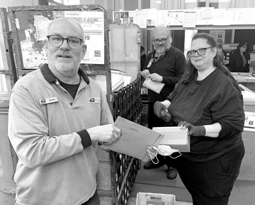 Port Townsend Post Office Employees (from left) Dean Massey, Christopher Thiry and Michelle Stimpson sort mail prior to delivery.