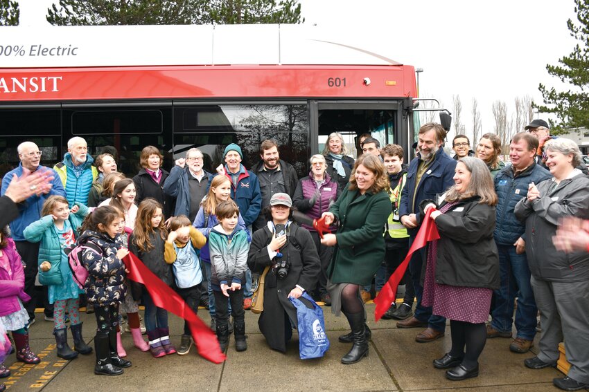 Jefferson County District 1 Commissioner Kate Dean cuts a ribbon on Dec. 6 at Port Townsend&rsquo;s Haines Place Park and Ride to celebrate Jefferson Transit Authority&rsquo;s first electric bus. Courtesy photo