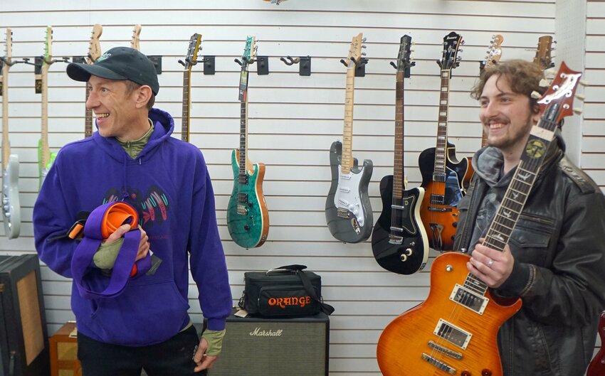 Tristan Marcum, left, meets with Quimper Sound guitar store manager Alex Ben-Barack to collect musical instrument donations. Photos by Charlie Bermant