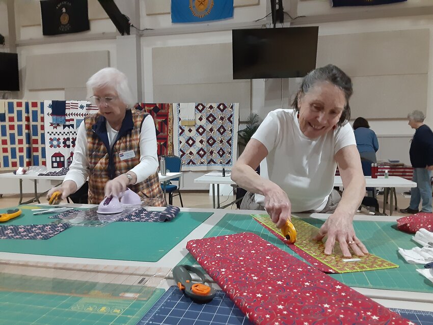 Quilts of Valor members Connie Davis and Susan Travis prep materials for a quilt. Photo by Kirk Boxtleitner