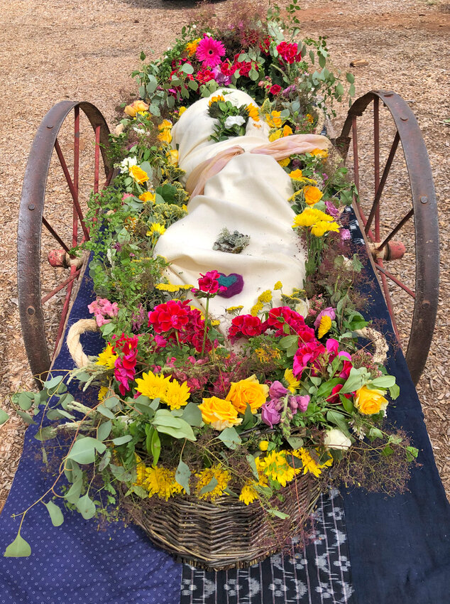 A willow &ldquo;soul boat&rdquo; is adorned in flowers and rests on a hand cart before its burial at White Eagle Memorial Preserve near Goldendale, Washington.