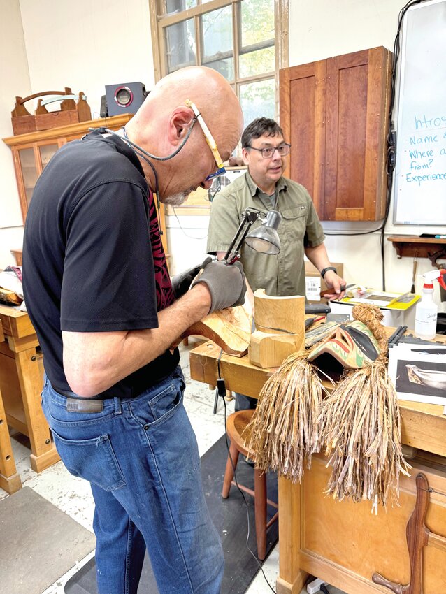 Class instructor Brian Perry looks on as a student makes a Nuu-Chah-Nulth mask.