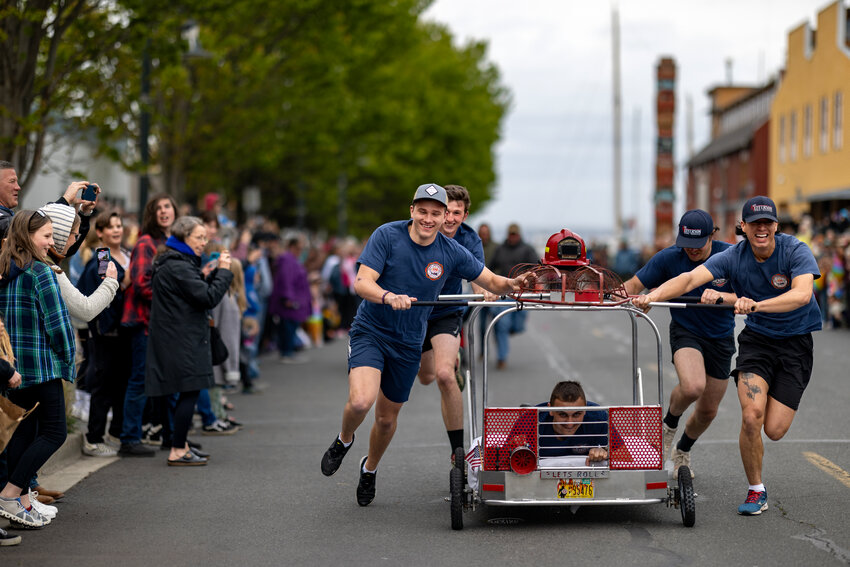 East Jefferson fire fighters push a makeshift bed-mobile down Water Street in downtown Port Townsend during the Rhody Fest Bed Races. See pages 14-15 for more photos.