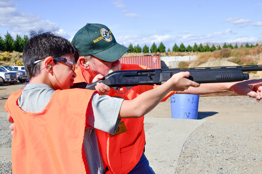 A hunter’s education instructor provides firearm safety training for a young hunter.