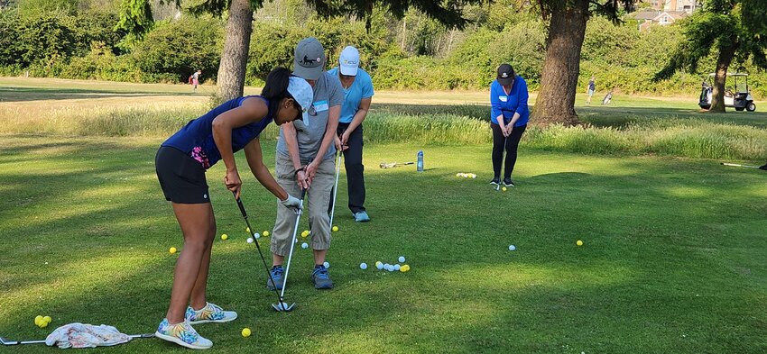 Jane Peoples, far left, instructs attendees of the Camus Prairie women’s golf clinic in July on ways to improve chip shots.