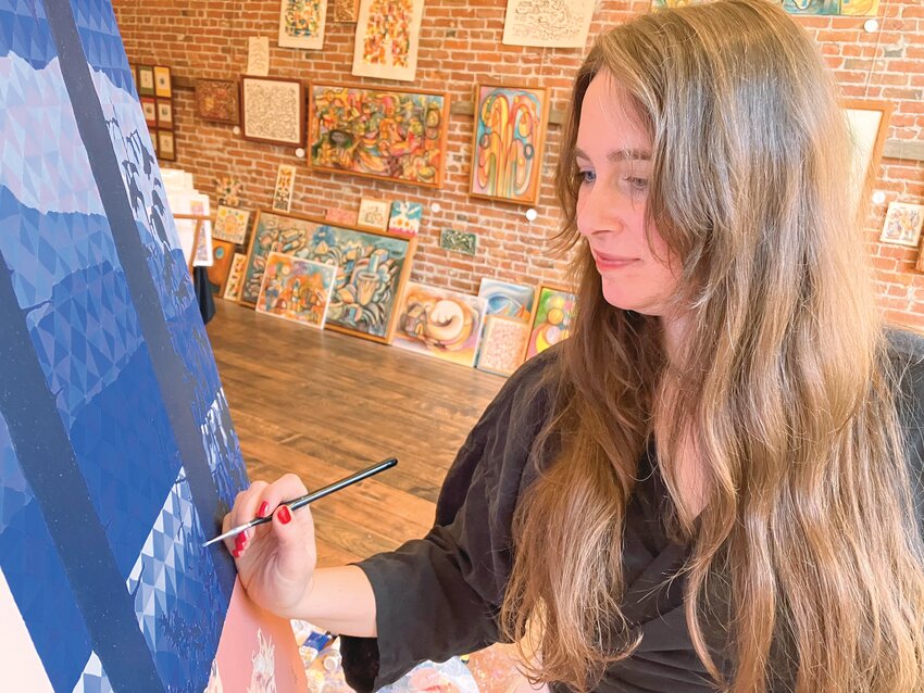 Brigid Grahan works on a painting at the Zee Tai Collective, which has stayed open late to invite the public to try their hands at creating art within the studio space on Water Street in downtown Port Townsend.