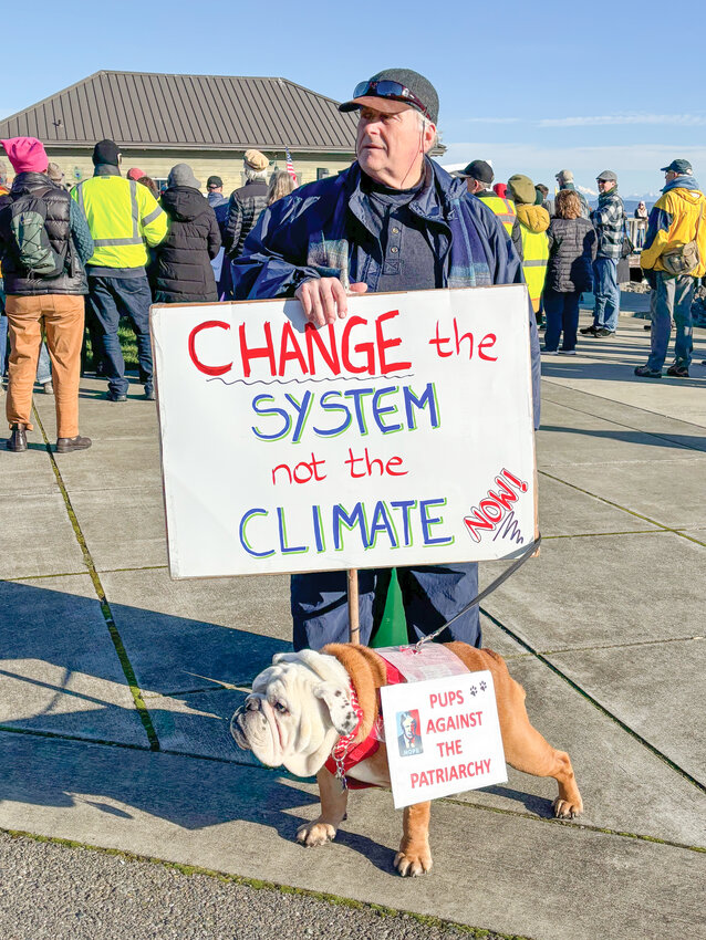 A man and his dog pose with signs on Saturday, Jan. 18, during the People&rsquo;s March at Pope Marine Park in downtown Port Townsend.