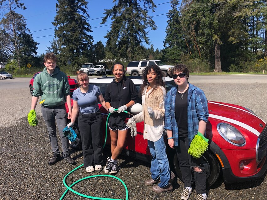 Members of Chimacum High School’s Interact Club pose for a photo on Saturday, April 12, while washing cars at Olympic Equipment Rental in Port Hadlock.