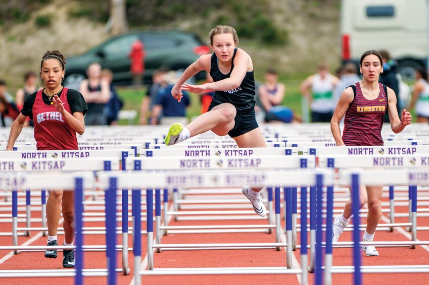 Sophomore Kadence Plotner, center, moves ahead of flanking rivals in the 100-meter hurdles on Saturday, April 19, at North Kitsap High School.