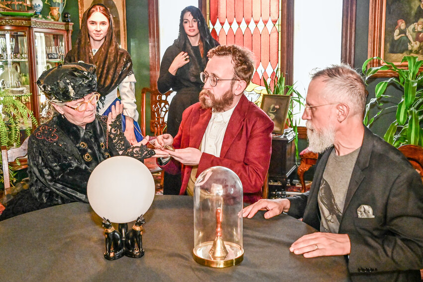 In front, “grieving widow” Joyce Hester, seance host Matt Bell and homeowner Joseph Lavy, and in back, ”unearthly spirit guides” Hazel Sanders and Angie Bell rehearse the staged seance they’ll present for this year’s Victorian Heritage Festival. Photo courtesy of Elizabeth Becker