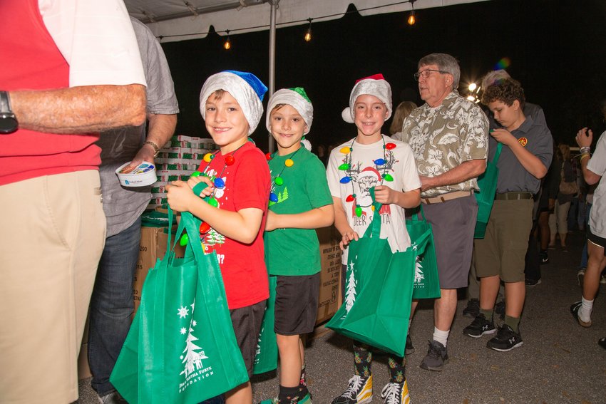 Jacob, Judah and Isaac McCutchan line up to help pack food bags.