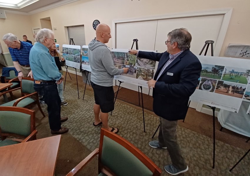 Bruce Hall, landscape architect for Catalyst Design Group, right, offers guidance to open house attendees as they indicate what attributes they want to see at future parks.